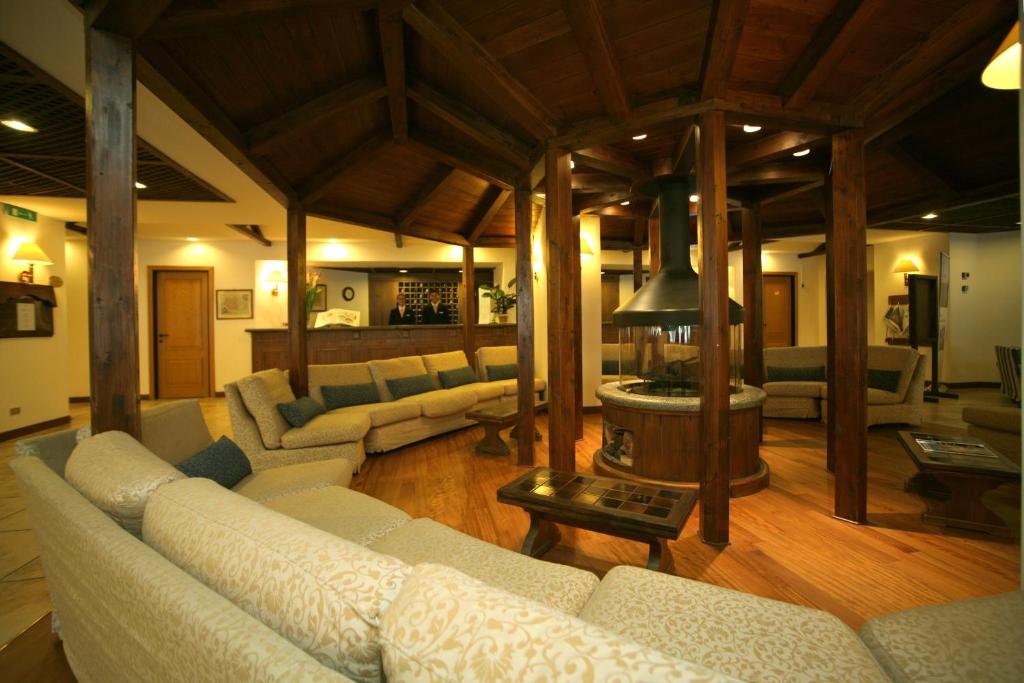 duży salon z kanapami i stołem w obiekcie Hotel Alaska Cortina w mieście Cortina dʼAmpezzo