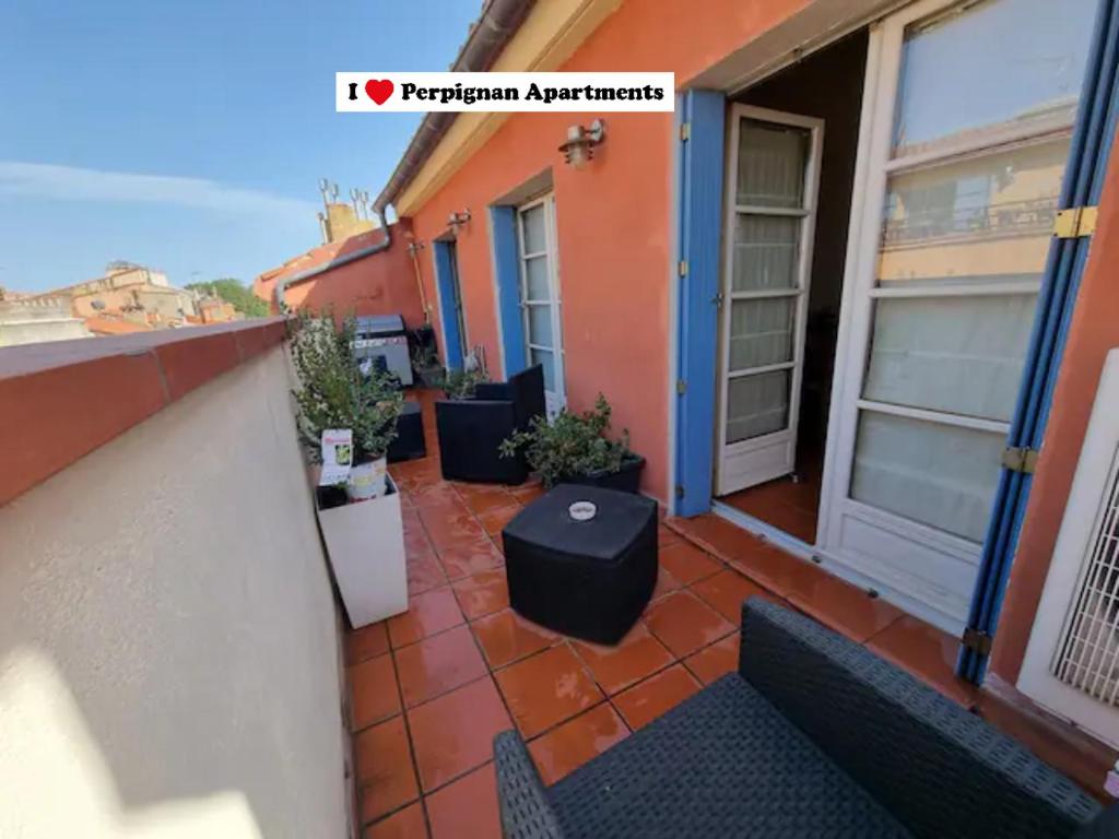 einen Balkon mit einem Tisch und Stühlen auf einem Gebäude in der Unterkunft I Love Perpignan Duplex Terrasse in Perpignan