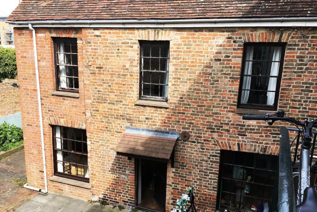 un edificio de ladrillo con cuatro ventanas. en Charming Cottage, Central Taunton. en Taunton