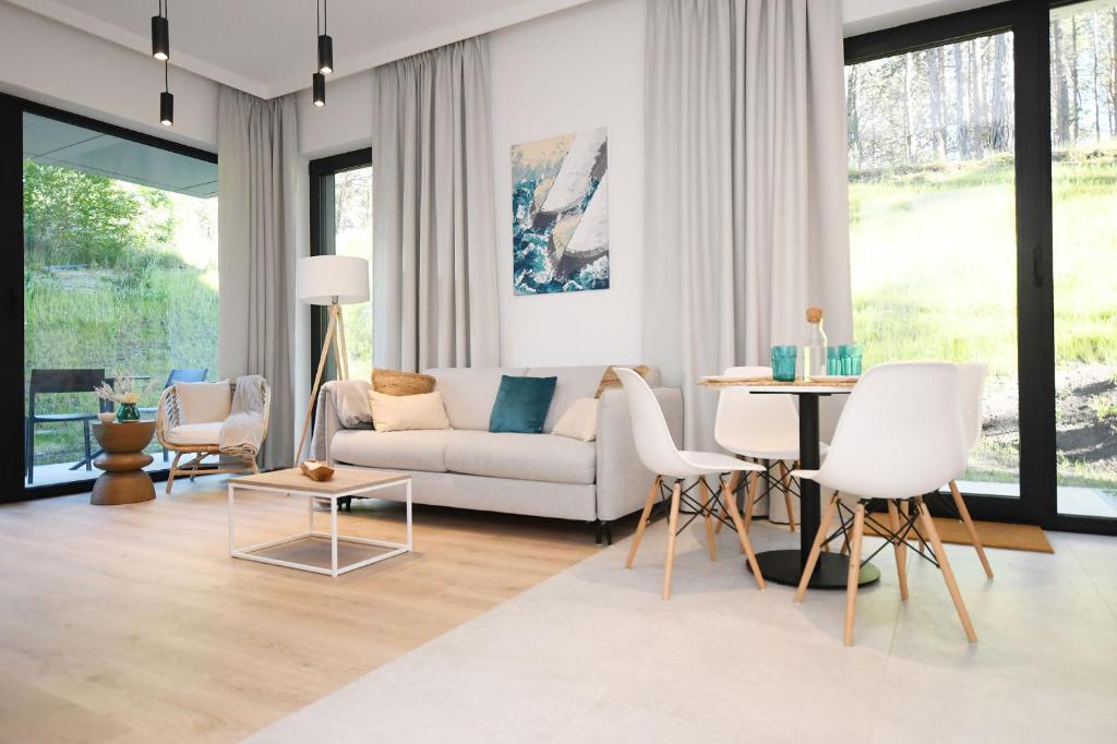 a living room with a couch and a table at SHELLTER Apartament Green Dune – Rogowo in Rogowo