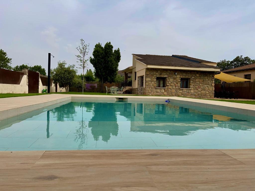 a large swimming pool in front of a house at La Casa OM in Almorox