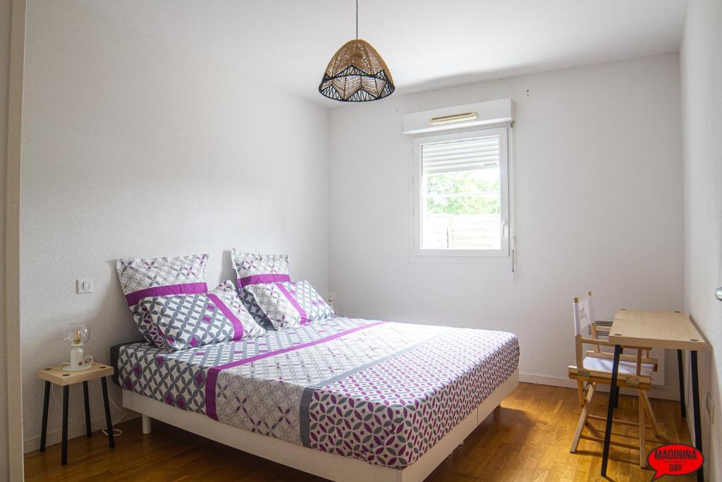 サン・メダール・アン・ジャルにあるMADININA DAYのベッドルーム1室(紫のシーツが敷かれたベッド1台、窓付)