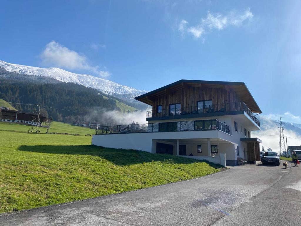 uma casa com um telhado de madeira numa montanha em Franzerl em Tux