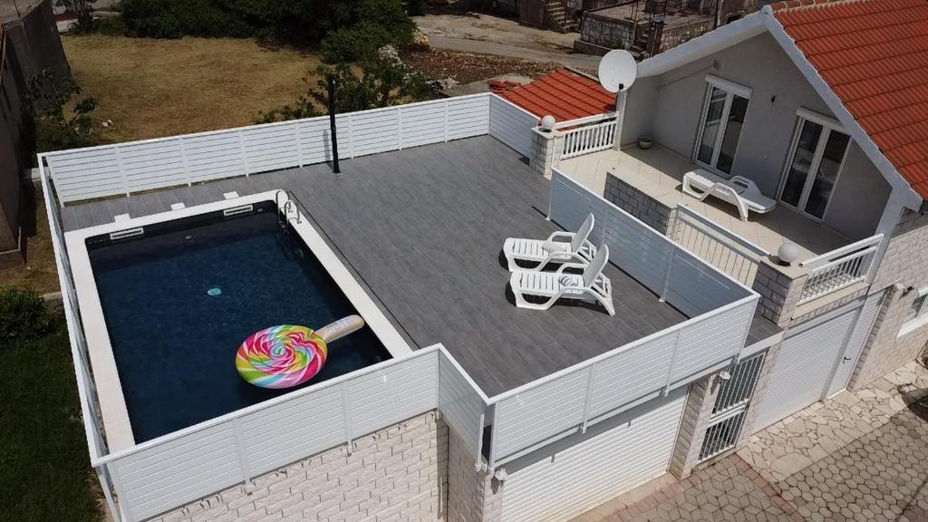 d'une terrasse avec une piscine, une table et un ballon. dans l'établissement Kroatien Villa Merćepi, à Katuni