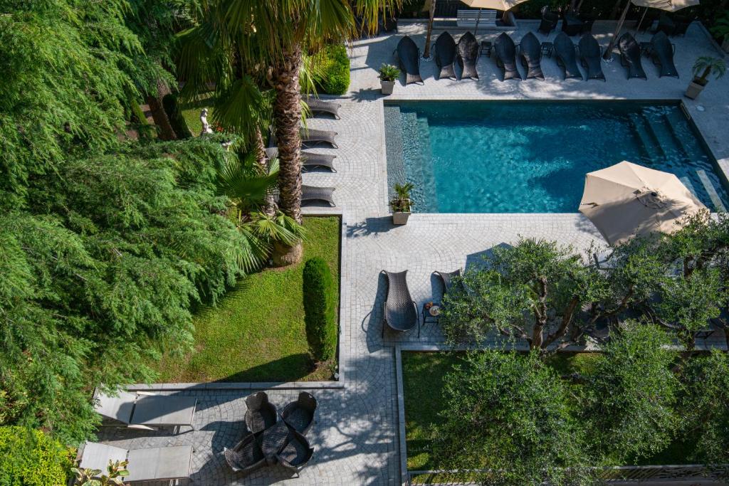 an overhead view of a swimming pool with chairs and trees at GOLDEN TULIP CANNES HOTEL de PARIS in Cannes