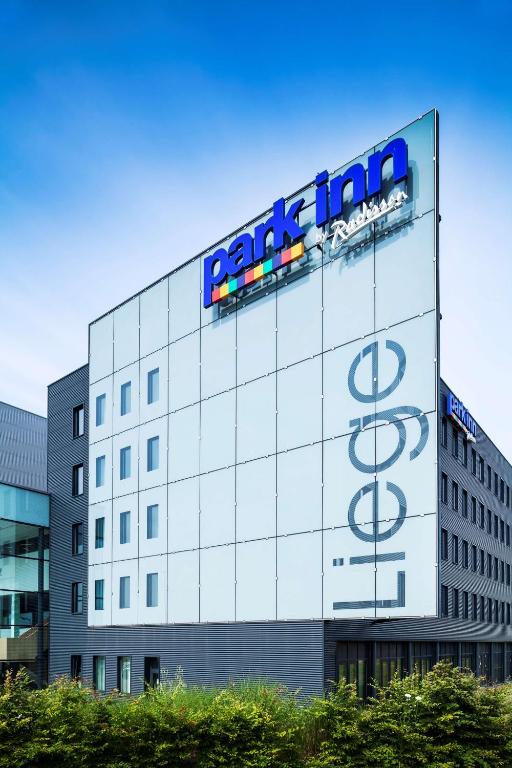 Un edificio con un cartel al costado. en Park Inn by Radisson Liege Airport, en Lieja