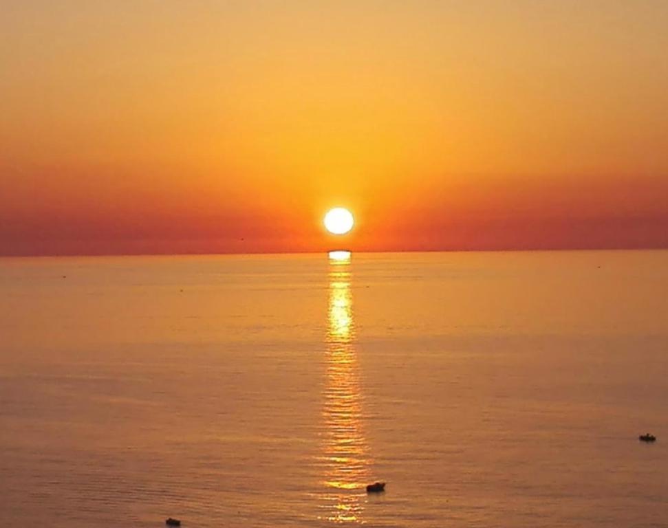 una puesta de sol sobre el océano con la puesta de sol en Sei ottavi en Gioiosa Marea