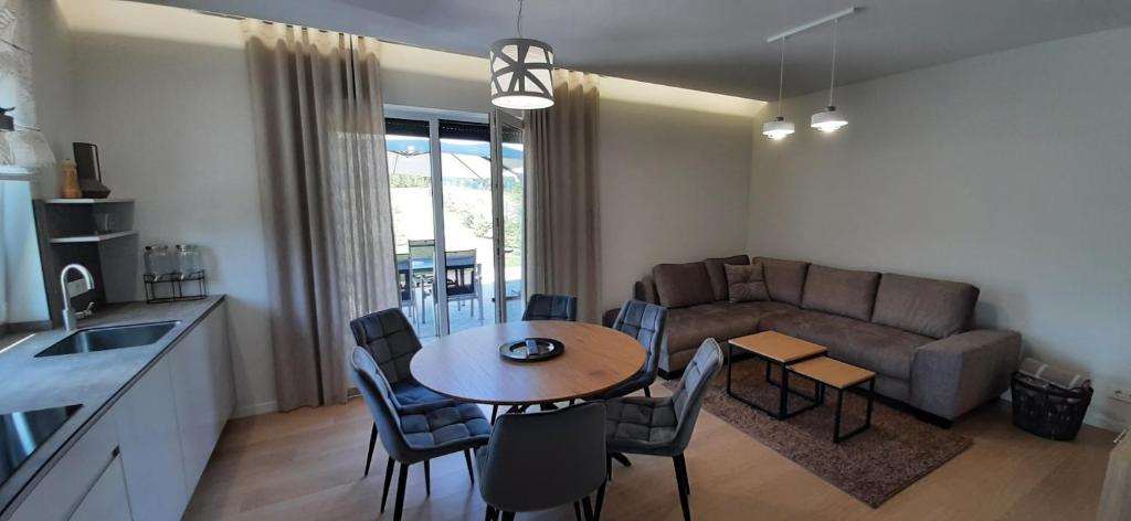 a kitchen and living room with a table and a couch at Vila Galadusis prie ežero in Lazdijai
