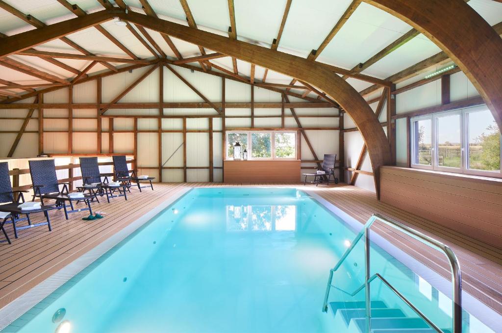 a large indoor pool with chairs and a table at Bauernhof Köhlbrandt in Todendorf auf Fehmarn