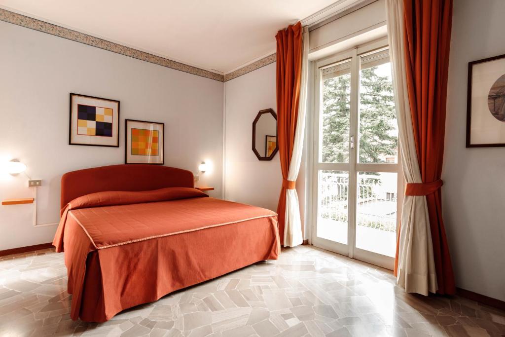 sypialnia z łóżkiem i dużym oknem w obiekcie Locanda Tradate w mieście Tradate