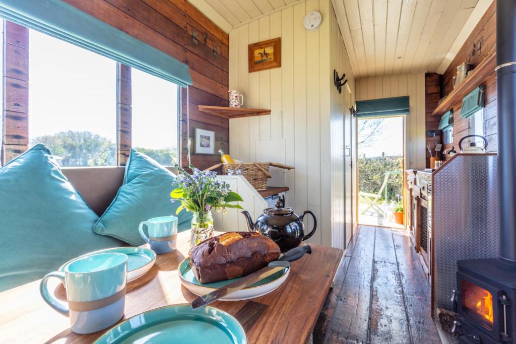 a table in a tiny house with a fireplace at The Hoot Romantic Glamping in Southwick