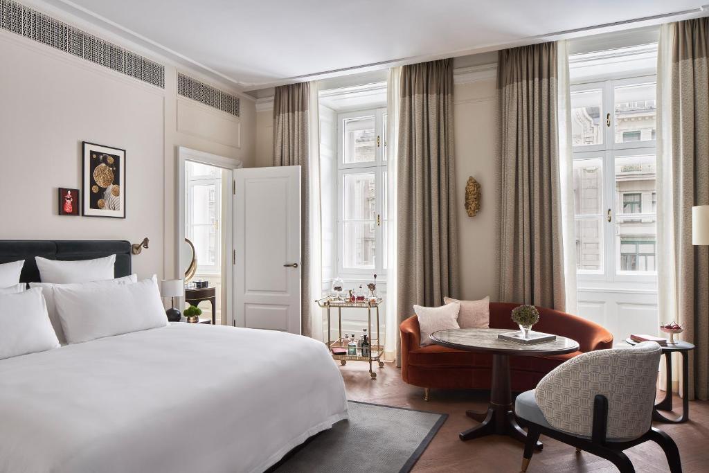 a bedroom with a bed and a table and a chair at Rosewood Vienna in Vienna