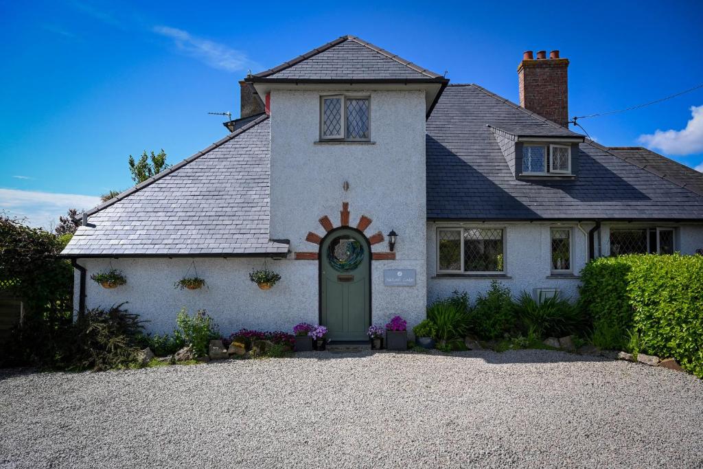 une maison blanche avec une porte verte dans l'établissement Halwell Lodge, à St Ives