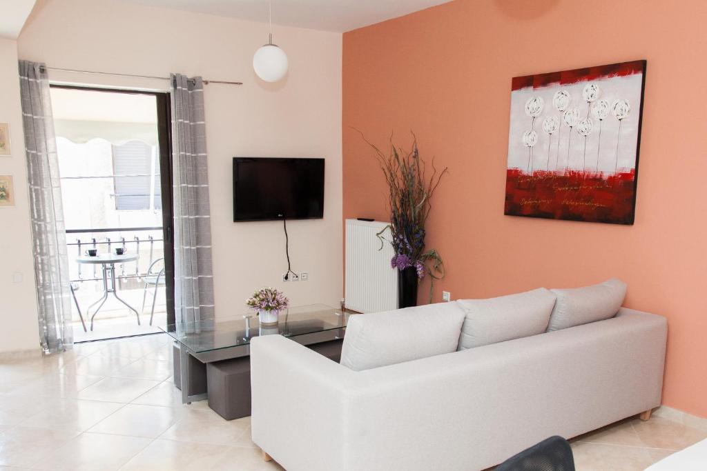 a living room with a white couch and a tv at Great Apartment in Piraeus in Piraeus