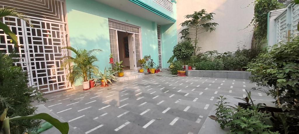 KANAK HOME STAY في فاراناسي: ساحة مع نباتات الفخار ومبنى