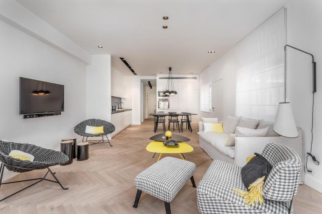 uma sala de estar com um sofá, cadeiras e uma mesa em Stunning and design 2BDR Apartment em Tel Aviv