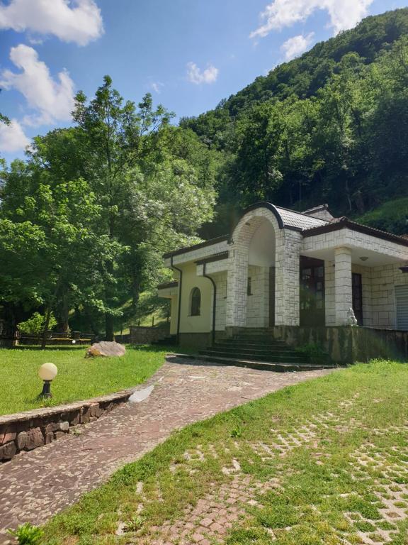 a house in a field with a hill in the background at Guest House Fedor in Ribarica