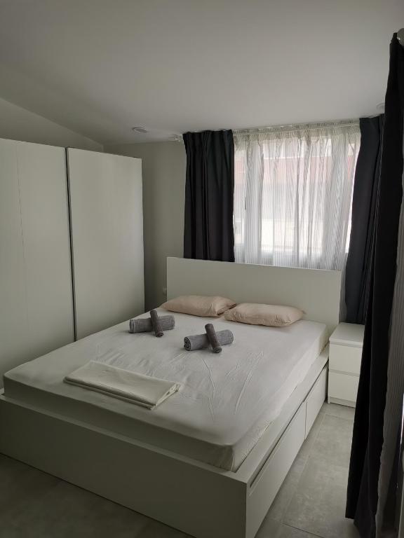 a bedroom with a large white bed with a window at SKG Central Deluxe Studios in Thessaloniki