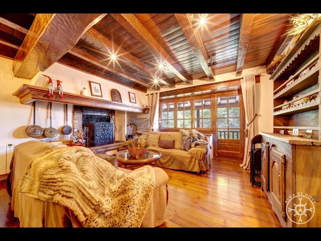 ein Wohnzimmer mit Sofa und Tisch in der Unterkunft CASA MARMOTA de Alma de Nieve in Baqueira-Beret