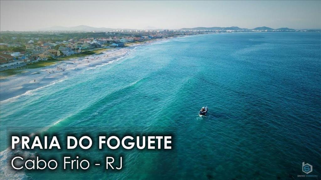 an aerial view of a boat in the ocean at Praia do Foguete - Aluguel Econômico in Cabo Frio