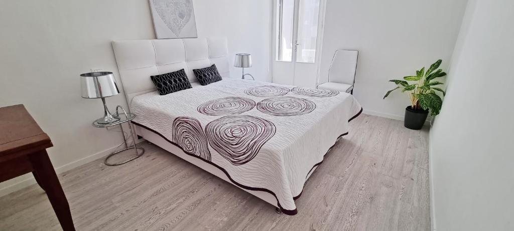 una camera da letto con un grande letto e un copriletto bianco di Casa Bianca - 2 Bedroom Design Apartment a Trieste