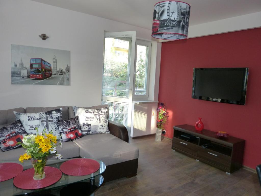 a living room with a couch and a flat screen tv at Maple Leaf Apartment in Krakow