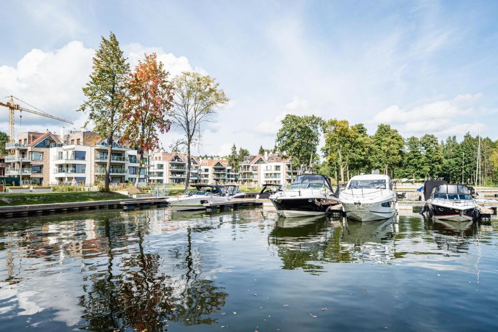 a group of boats are docked in a harbor at Good Morning Sunshine - Nautica Resort Apartment in Giżycko