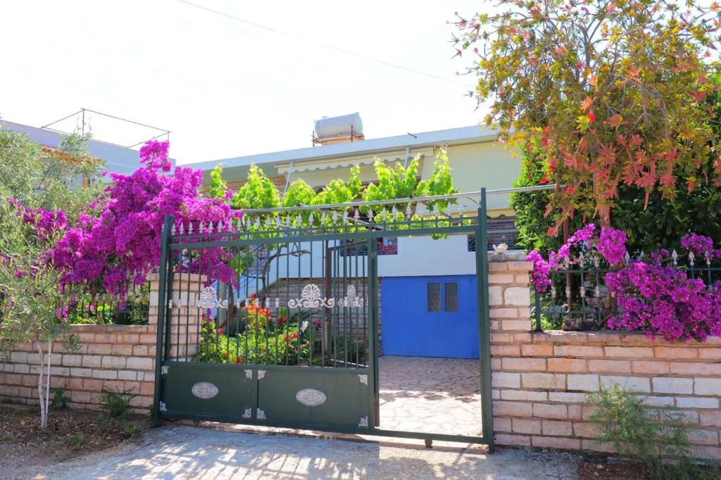 brama ogrodowa z kwiatami i fioletowymi kwiatami w obiekcie Vita Apartament w mieście Ksamil