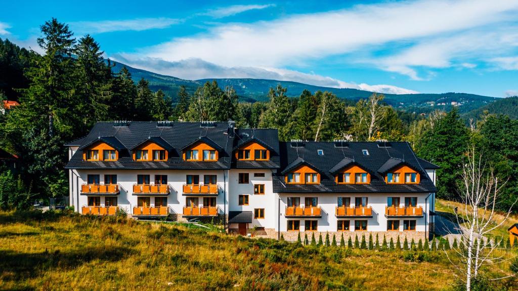 a large white building with orange windows on a hill at Stacja 605 in Karpacz