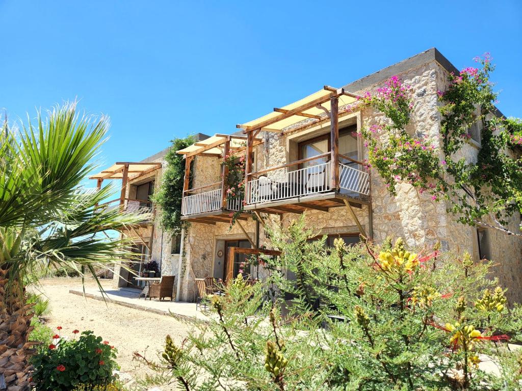 a stone building with balconies and plants at Eco Farm Boutique Hotel in Turgutreis