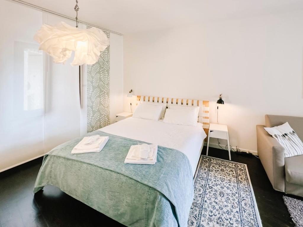 CRUdiS Luxury rooms في سان دانييلي ديل فريولي: غرفة نوم بسرير كبير وكرسي