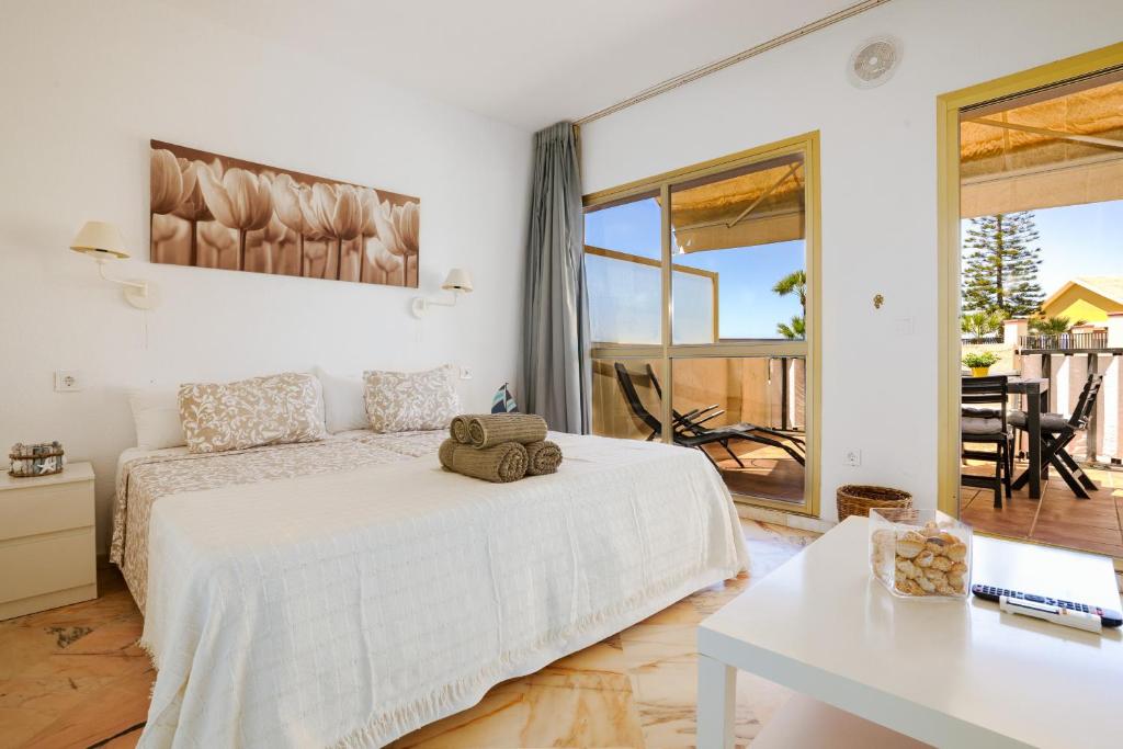 um quarto branco com uma cama e uma mesa em Romana playa 724 em Marbella