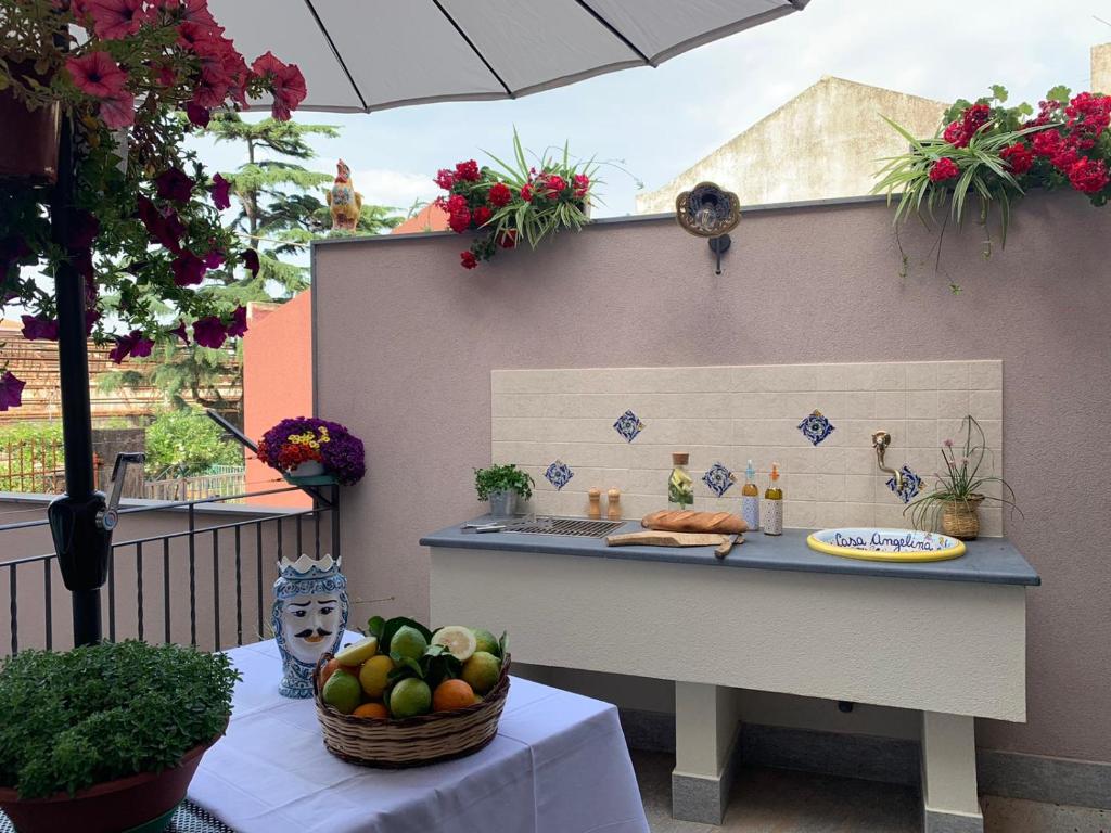 un tavolo con bancone e ciotola di frutta di Casa Angelina a due passi dal mare ad Acireale