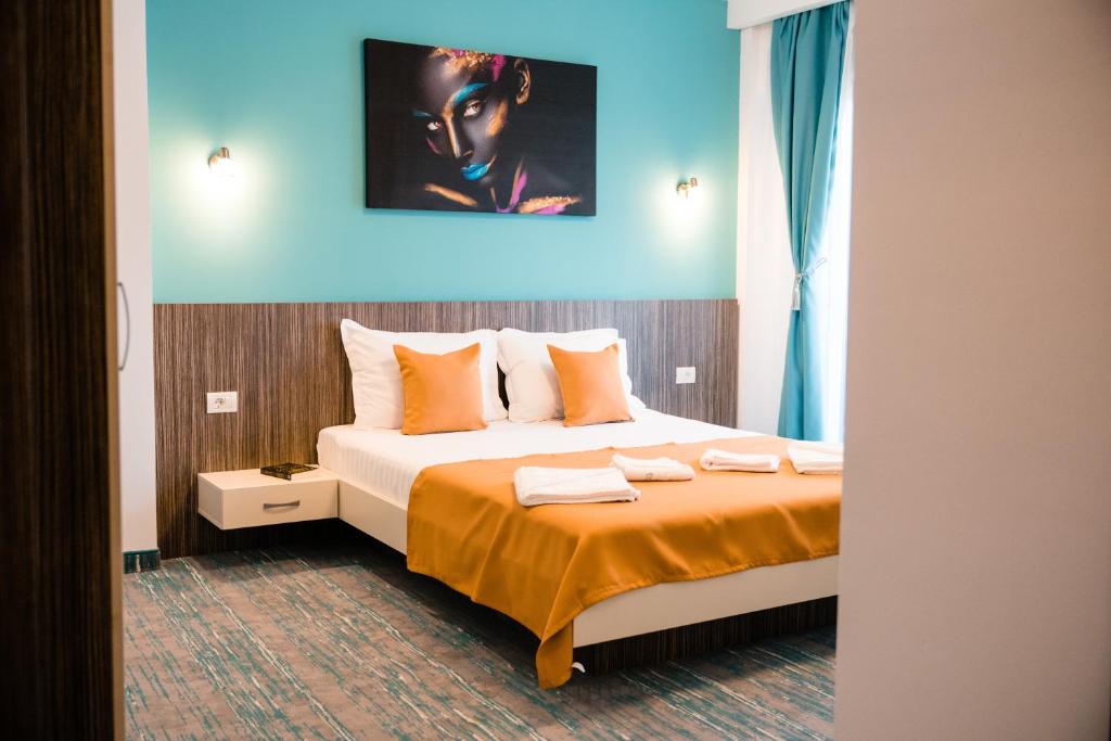um quarto de hotel com uma cama com lençóis laranja em Vila GRANDE MAMAIA NORD em Mamaia Nord – Năvodari