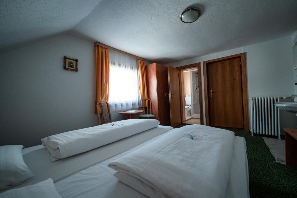a hotel room with two beds and a window at Hotel Tauernpasshöhe in Obertauern