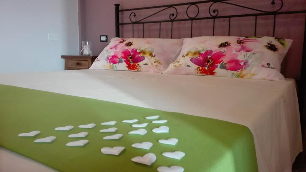 Una cama con una manta verde con corazones. en Ortona Holidays Country House, en Ortona