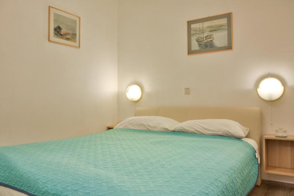 a bedroom with a bed with two lights on the wall at Apartments Miki in Donja Klada