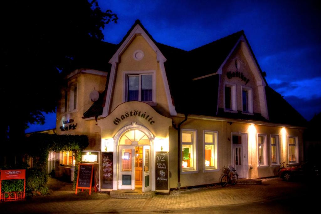 un magasin devant une maison la nuit dans l'établissement Restaurant und Pension Zur Nassen Ecke, à Wittenbeck