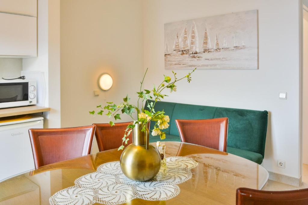 a dining room table with a vase with flowers in it at Apartments Miki in Donja Klada