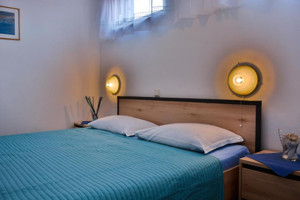 a bedroom with a blue bed with two pillows at Apartments Miki in Donja Klada
