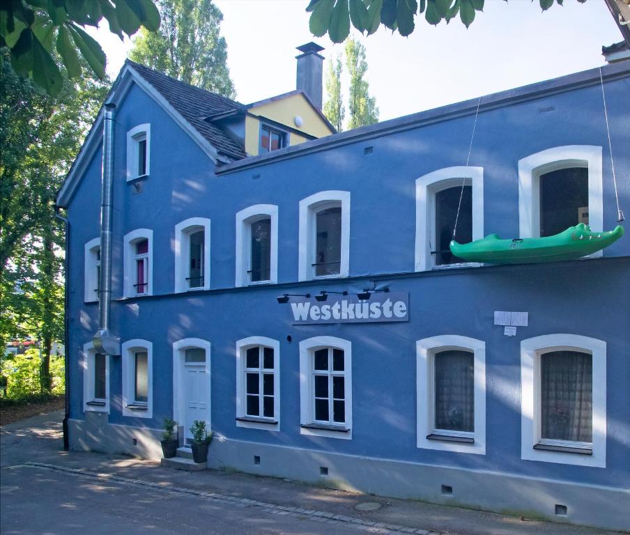 niebieski budynek z łodzią na górze w obiekcie Hostel Westküste w mieście Lindau
