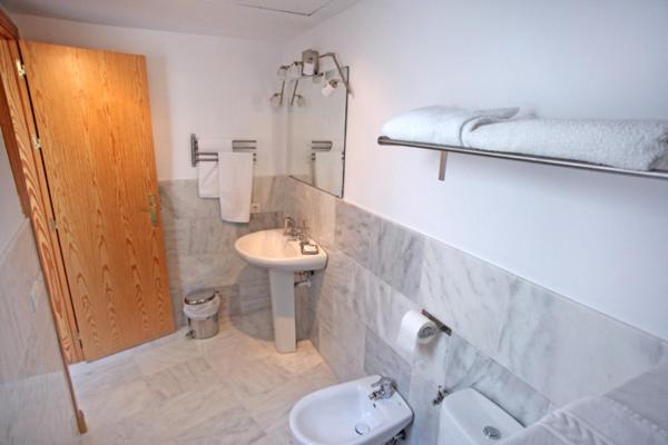 uma casa de banho branca com um lavatório e um WC em Sleepin Sevilla em Sevilha