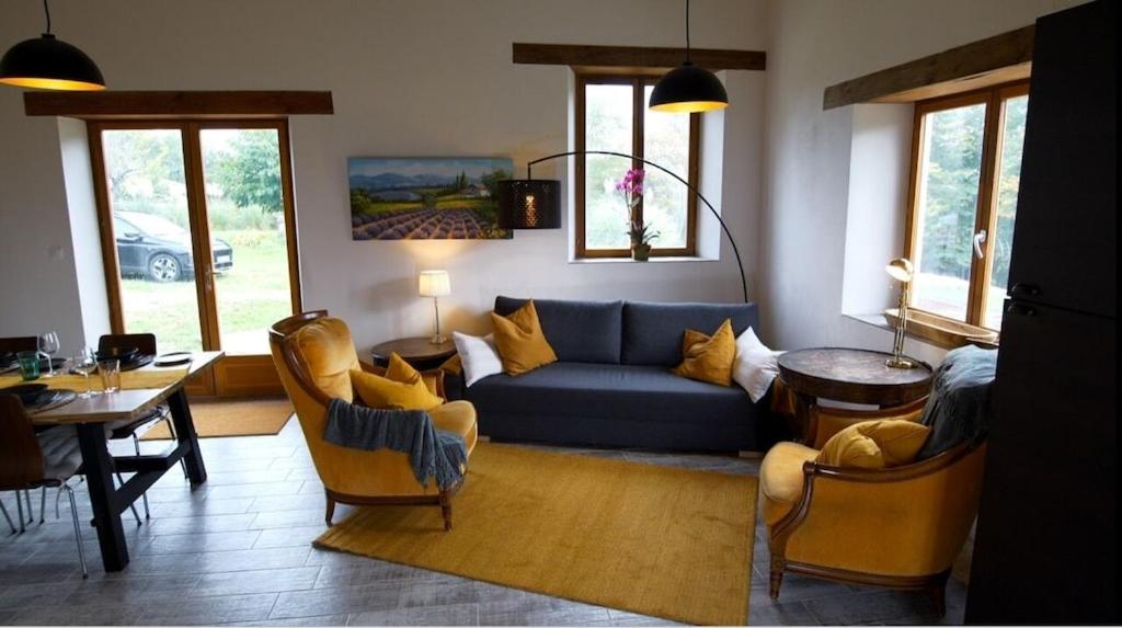 uma sala de estar com um sofá azul e cadeiras em Walnut Lodge Espas 2 bedroom, Barn Conversion em Espas