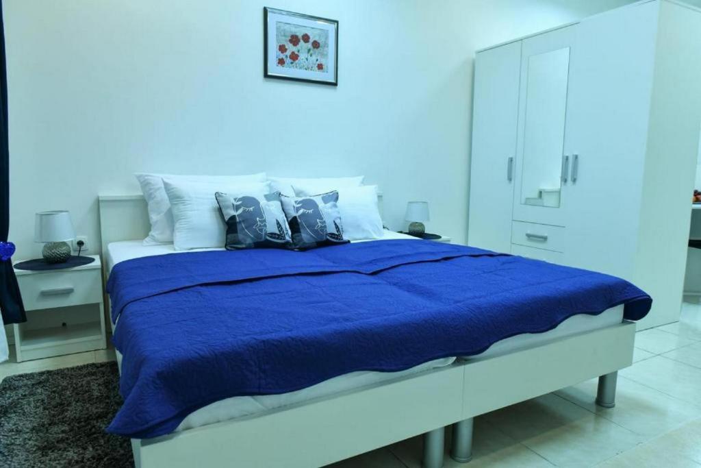 Studio Apartments Kamicak في سيني: غرفة نوم زرقاء مع سرير كبير مع شراشف زرقاء
