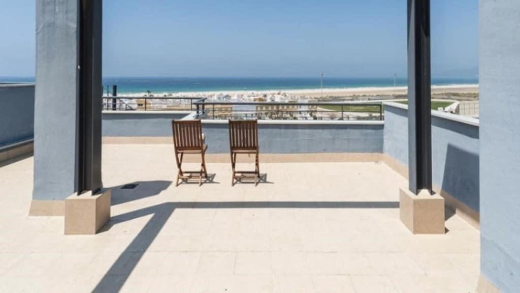 two chairs sitting on a patio near the beach at ático Tarifa in Tarifa