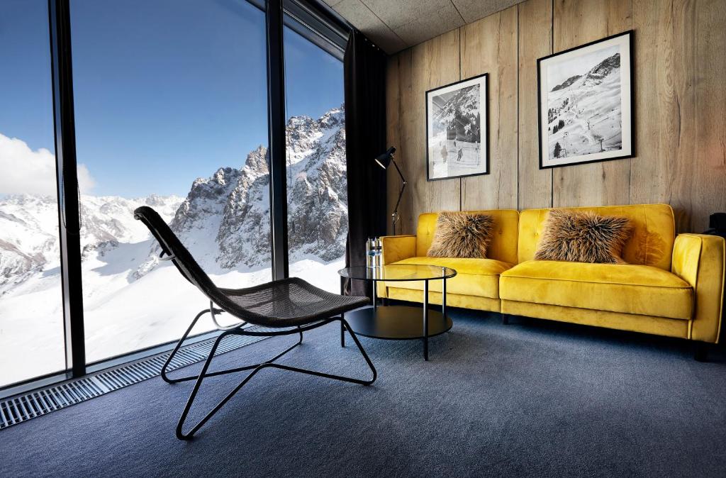 a living room with a yellow couch and a table at Tenir Eco Hotel, Shymbulak Mountain Resort in Almaty