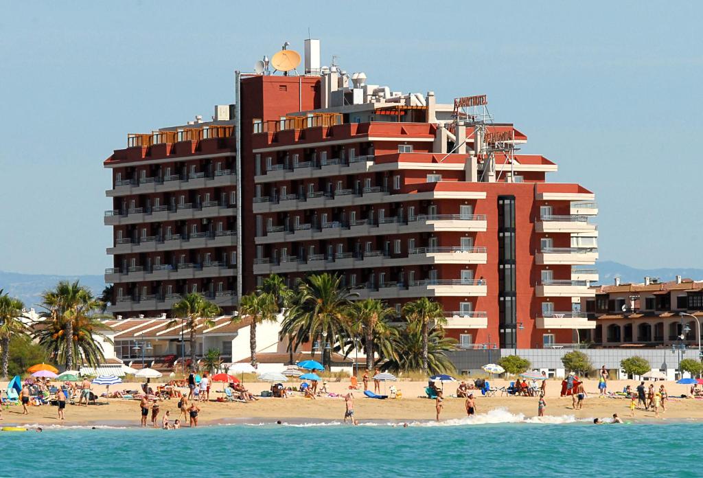 un gran hotel en una playa con gente en la playa en Aparthotel Acualandia, en Peñíscola