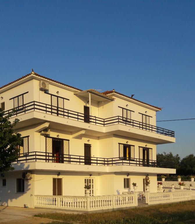 a large white building with balconies on it at Kypseli Farmhouse in Kypseli