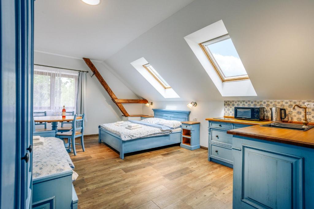 una cucina con armadi blu e un letto in una camera di KNÍŽECÍ DŮM - ubytování v Lednici a Lednice