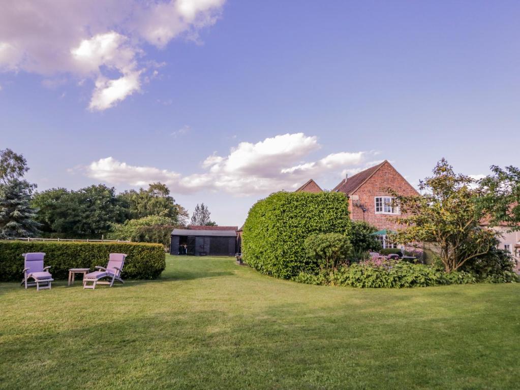 a yard with two chairs and a house at Little Pontus in Canterbury